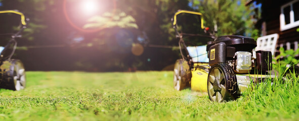 Lawn mower cut grass. Garden work. Electric Rotary lawn mower machine. Panorama, banner