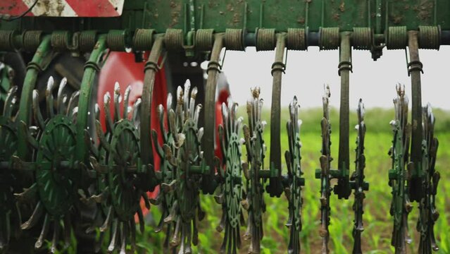Footage of a green rotary hoeing in the field