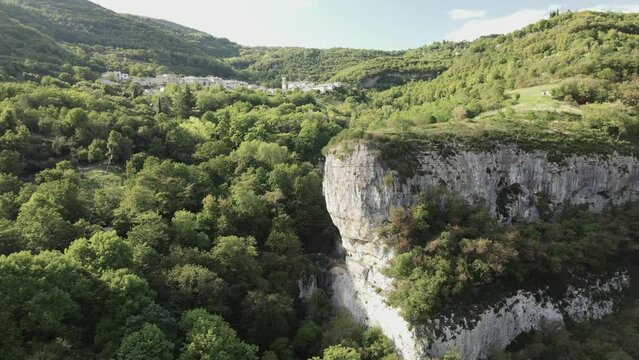 Drone rising view of the green mountains landscape in Molina di Ledro under the blue sky