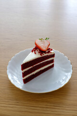 pieces of red velvet cake,tree layer with cream cheese frosting on white dish.Homemade bakery concept..
