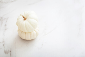 white pumpkins on white marble background