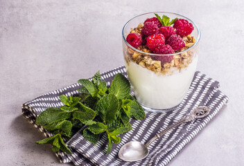 Glass of homemade yogurt with raspberries and granola