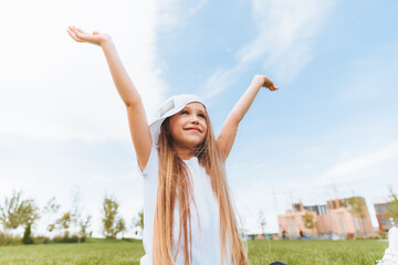 a little girl rejoices with her hands raised. the child raises his hands to the sky