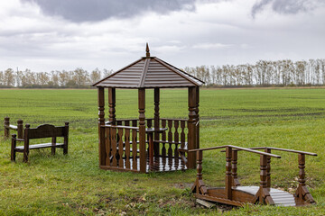 wooden gazebo in the park during the rain