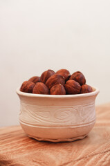 Hazelnut in a bowl on a wooden table,gray background. Hazelnuts without shell