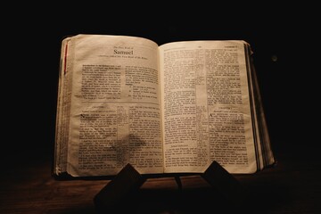 Closeup shot of a historic old Bible open on the Samuel pages on display in a dark room