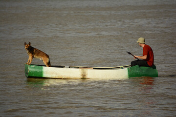 rowing boat on the river with a dog on one end. rowing canoe
