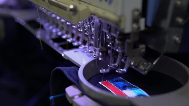 Embroidery machine in progress embroidery company logo on uniform in Textile Industry at Garment Manufacturers.