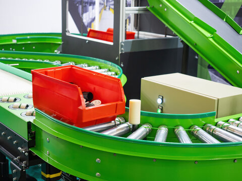 Transportation of goods within warehouse. Conveyor belt. Red plastic container on transportation line. Modern conveyor belt for automation of warehouse processes. Conveyor equipment