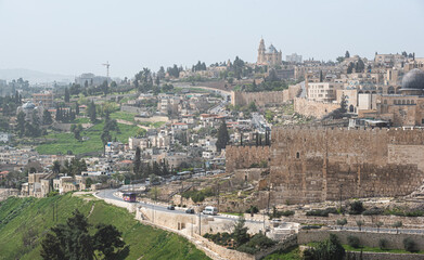 Fototapeta na wymiar View from above over Jerusalem fortress and wall with the cemetery from Mount of Olives in foreground. Landmark landscape view of this city from Israel.