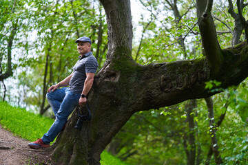 Naklejka na ściany i meble Travel photographer hiking in the forest mountains with his camera