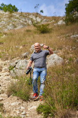 Naklejka premium Travel photographer hiking in the forest mountains with his camera