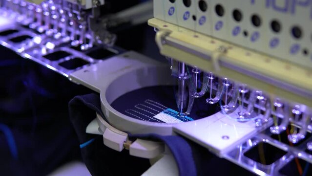 Embroidery machine in progress embroidery company logo on uniform in Textile Industry at Garment Manufacturers.