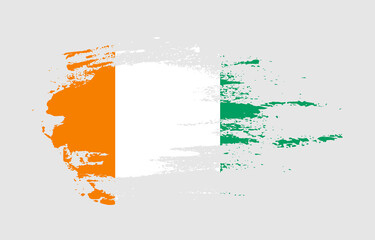 Grunge brush stroke flag of Cote dIvoire with painted brush splatter effect on solid background