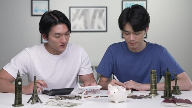 Young Asian gay couple saving money. LGBT couple making savings plan for travel and vacation.