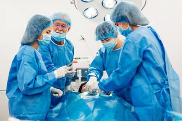 Professional anesthesiologist doctor medical team and assistant preparing patient to gynecological surgery performing operating with surgery equipment in modern hospital operation emergency room
