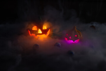 Halloween pumpkin face lantern at night with misty smoke. Thick gray smoke comes out and spreads...