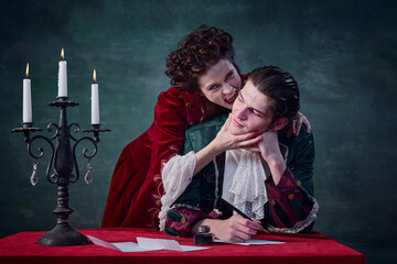 Portrait of young man writing letter and woman in image of vampire biting his neck over dark green...