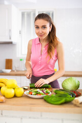 Obraz na płótnie Canvas Woman cutting vegetables cooking dinner at home