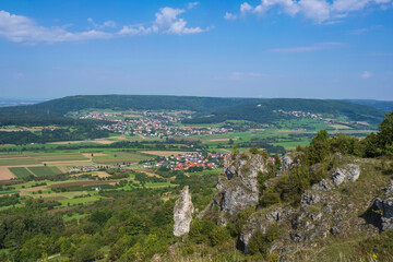Obraz premium View from the summit of the Ehrenbürg on a rock formation below with a wide view of Franconian Switzerland/Germany