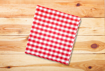 Colorful checkered napkin on wooden background top view
