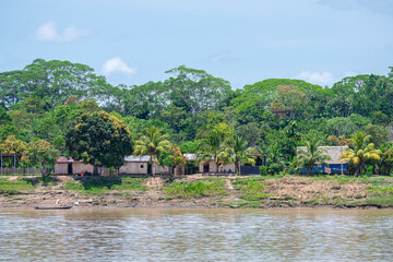 riverbank view of peruvian amazon with shanty houses at background
