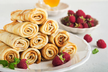 Pancakes. Stack of crepes or thin pancakes with berries, with raspberries and honey for breakfast. Homemade breakfast. Copy space. Selective focus.