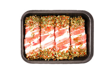 Raw mixture meat sausages - traditional Balkan food cevapcici or Romanian mititei ready for grilling. Minced meat rolls wrapped with bacon and spices in black plastic container isolated on white
