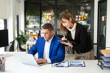 working together on a project two young business colleagues working on a computer at modern office