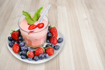 Tasty sweet milk smoothie with strawberry on the table