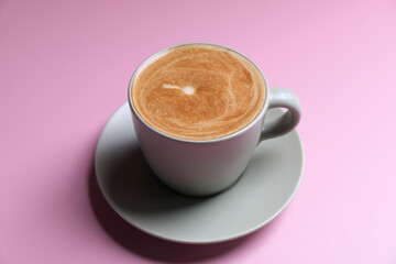 hot cappuccino with latte art isolated in pink background