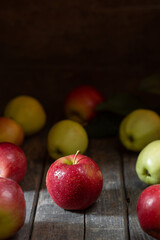 Red apple in water drops on wooden background texture
