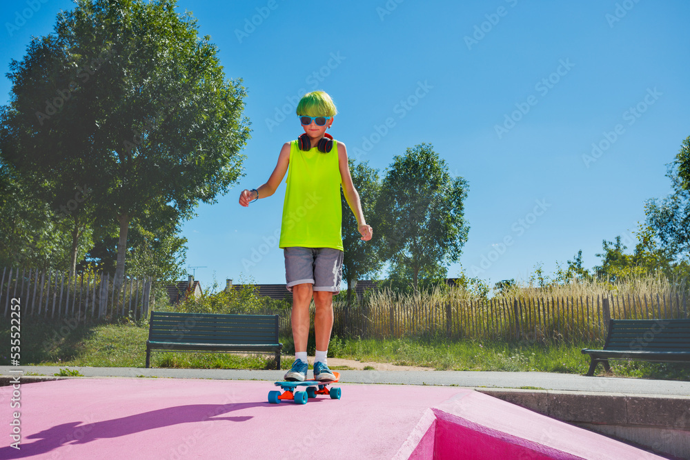 Wall mural Boy with green hair ride skateboard at skatepark wear sunglasses