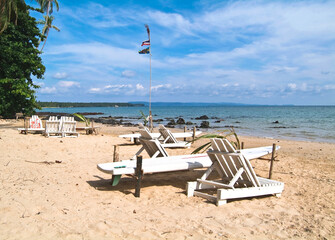 white chairs on the sandy beach near the sea