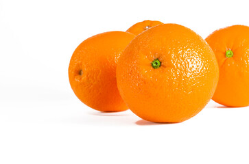 A harvest of ripe juicy oranges lies on a white background
