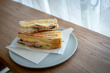sandwish ham cheese spinach in a dish on a wood table