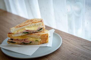 sandwish ham cheese spinach in a dish on a wood table