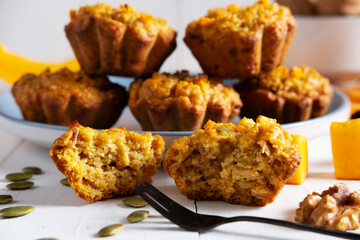 Highlighted focus on a broken pumpkin muffin next to the fork. Healthy dietary food, healthy breakfast or snack.