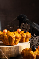 Pumpkin muffins with close-up Halloween decorations, vertical orientation. Healthy snack on the holiday