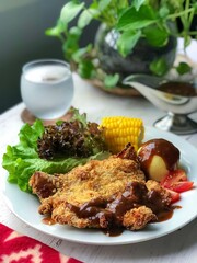 The chicken chop with black pepper source, mashed potatoes, corn and vegetables in the white plate on the white background.Ready to eat.chichen chop fry with air fryer or deep fried.