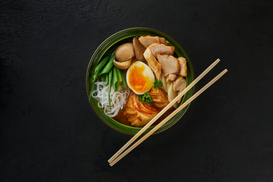 Traditional Japanese soup with meat broth, asian rice noodles, sliced chiken, eggs. Close up. Asian style food. Top view. Hot tasty ramen soup for dinner.