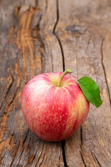 Single apple with leaf on an old farm table