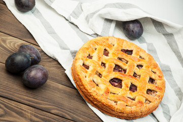 shortcake with plums on a wooden table. the concept of homemade shortcrust pastry. baked fruit dessert on the kitchen table close up