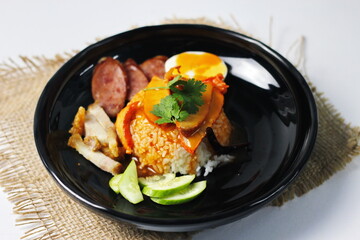 rice with roasted pork on top served with cucumber, boiled egg, crispy pork and bbq sauce that are sold in many places in Thailand.Barbecued red pork in sauce with rice is a popular food in Thailand.