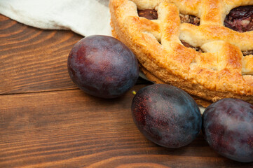 shortcake with plums on a wooden table. the concept of homemade shortcrust pastry. baked fruit dessert on the kitchen table close up