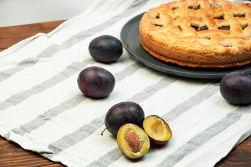 shortcake with plums on a wooden table. the concept of homemade shortcrust pastry. baked fruit dessert on the kitchen table close up
