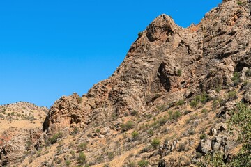 Fototapeta na wymiar A rocky ledge with sharp edges on a mountain slope in the mountains of Armenia.