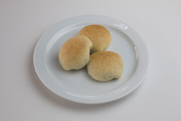 3 chocolate buns isolated on a round white plate