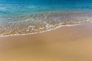 Fototapeta na wymiar Plage et mer montrant le sable et l'eau bleu émeraude pour arrière-plan, espace pour slogan texte