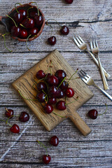 Layout of juicy cherries on a wooden background. Top view, vertical